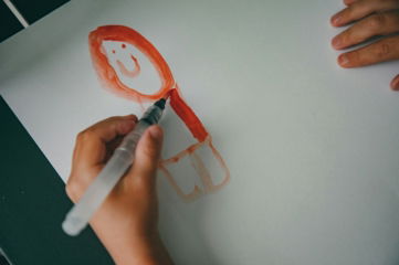 a child's drawing of a smiling face on a piece of paper